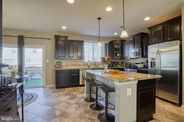 a kitchen with stainless steel appliances granite countertop a stove refrigerator sink and microwave