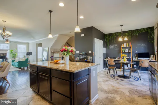 a room with stainless steel appliances kitchen island a table and chairs in it