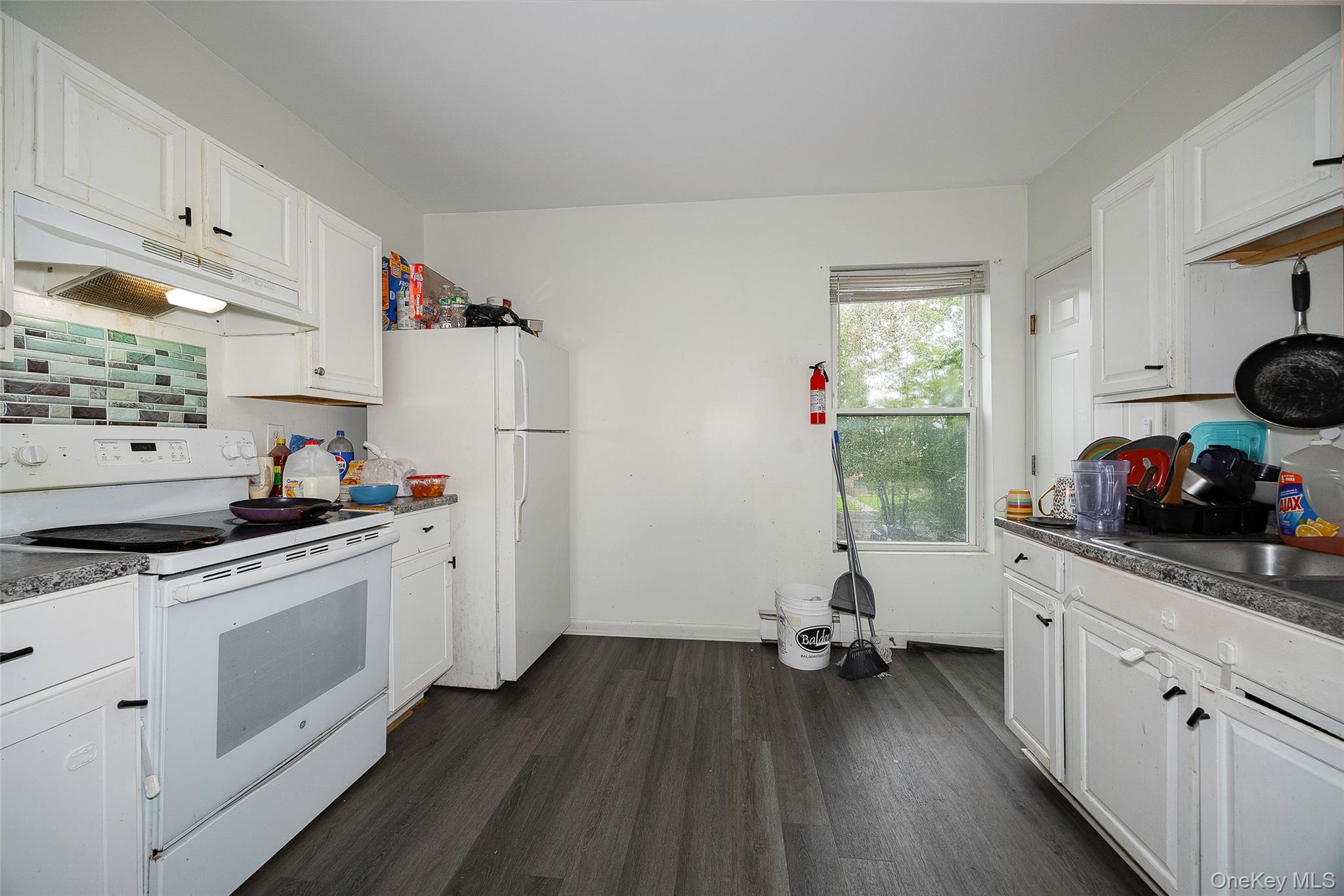 52 Parker Avenue Poughkeepsie, NY 12601 - Photo 3 of 12 a kitchen with a sink dishwasher stove and white cabinets with wooden floor