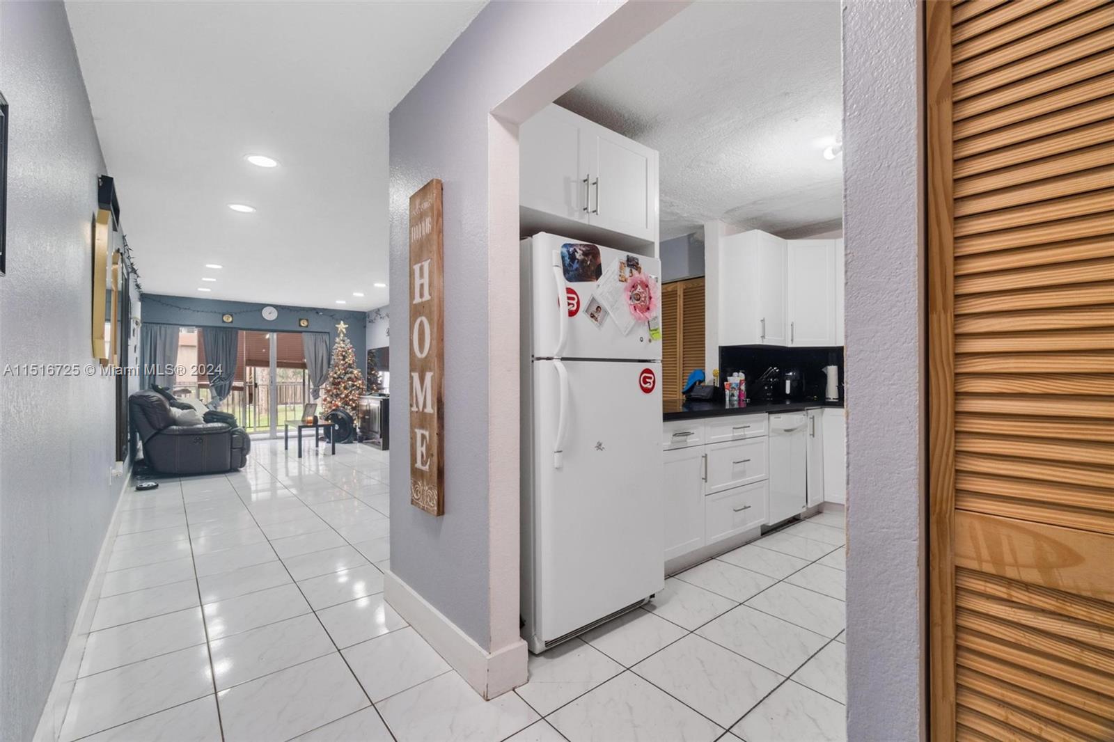 1900 West 68th Street, Unit E104 Hialeah, FL 33014 - Photo 11 of 31 a kitchen with stainless steel appliances kitchen island granite countertop a refrigerator and a sink