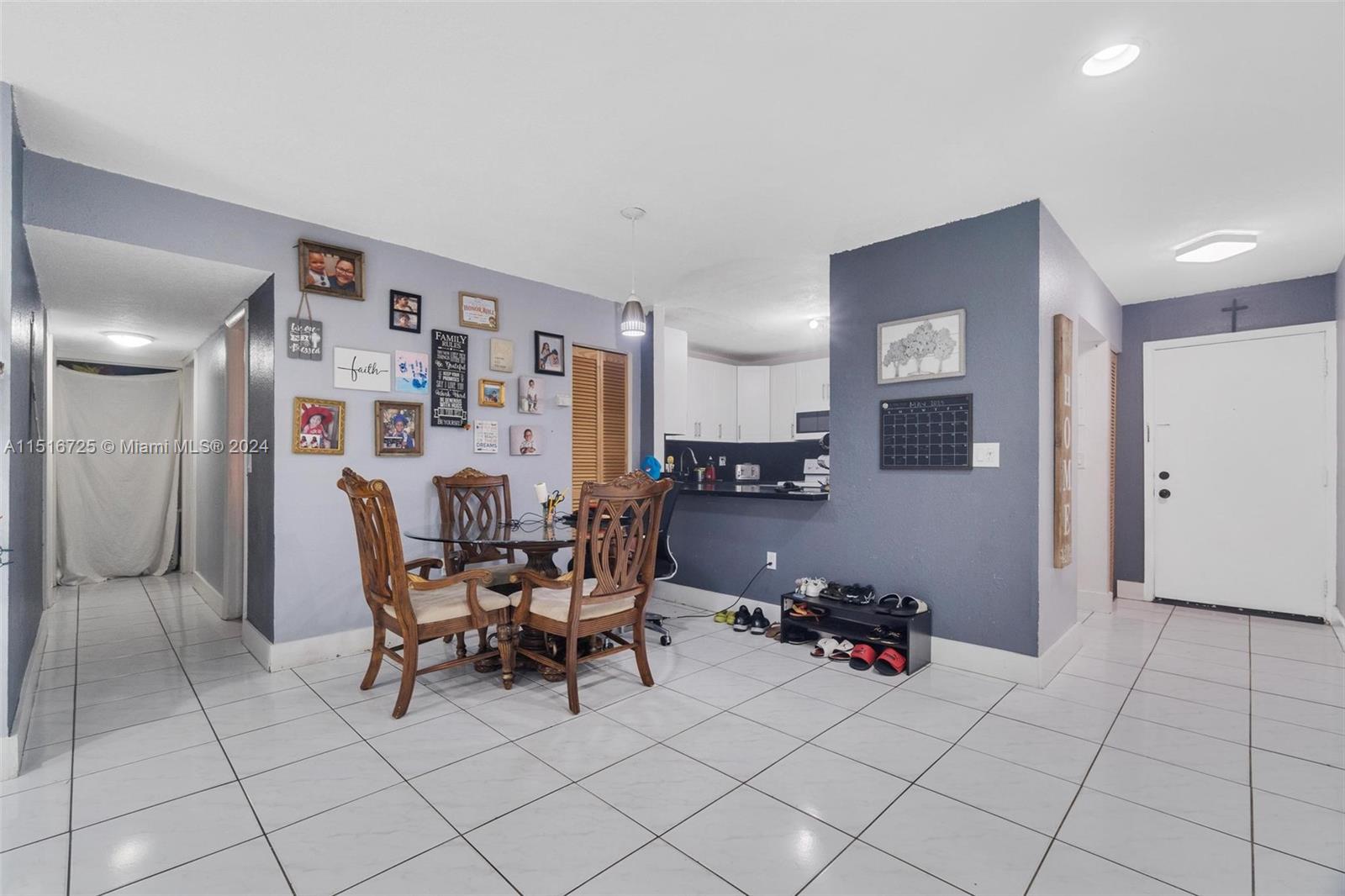 1900 West 68th Street, Unit E104 Hialeah, FL 33014 - Photo 14 of 31 a living room with furniture and a dining table with kitchen view