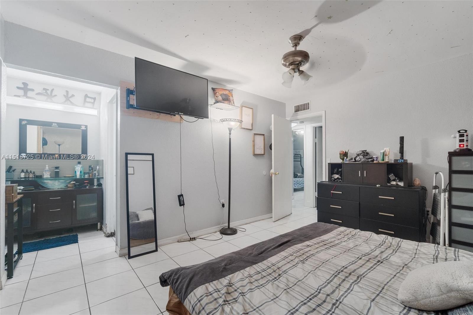 1900 West 68th Street, Unit E104 Hialeah, FL 33014 - Photo 18 of 31 a bedroom with a bed and a flat tv screen
