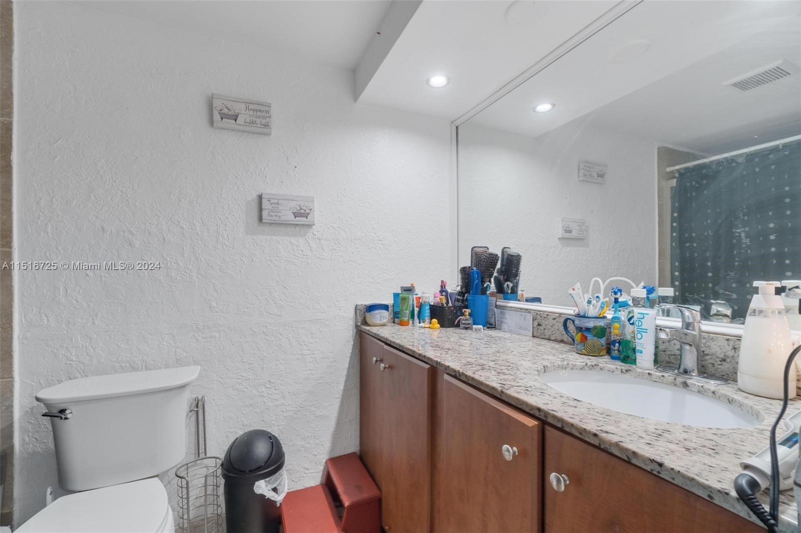 1900 West 68th Street, Unit E104 Hialeah, FL 33014 - Photo 19 of 31 a bathroom with a granite countertop sink and a toilet