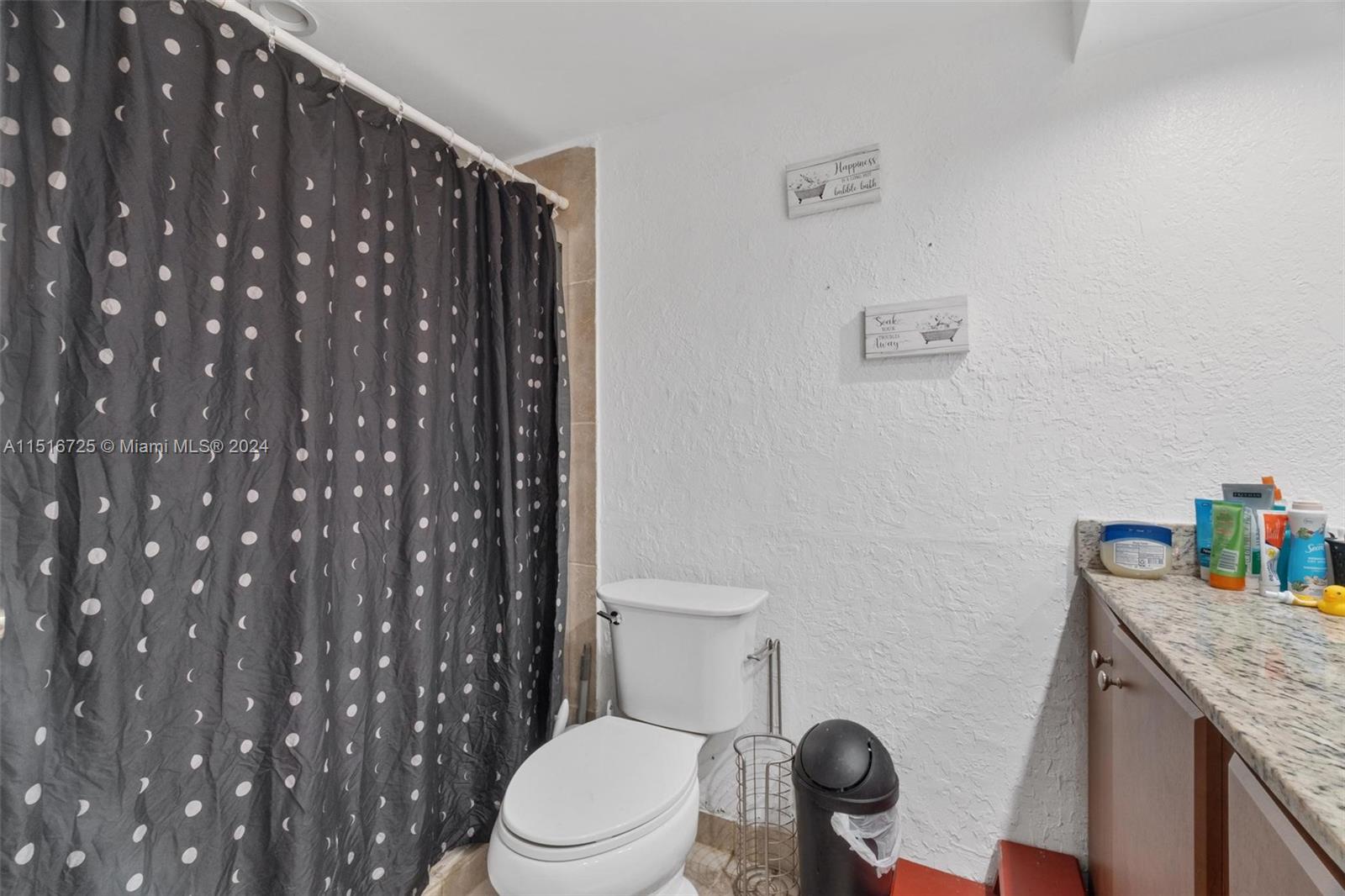 1900 West 68th Street, Unit E104 Hialeah, FL 33014 - Photo 20 of 31 a bathroom with a granite countertop toilet and a sink