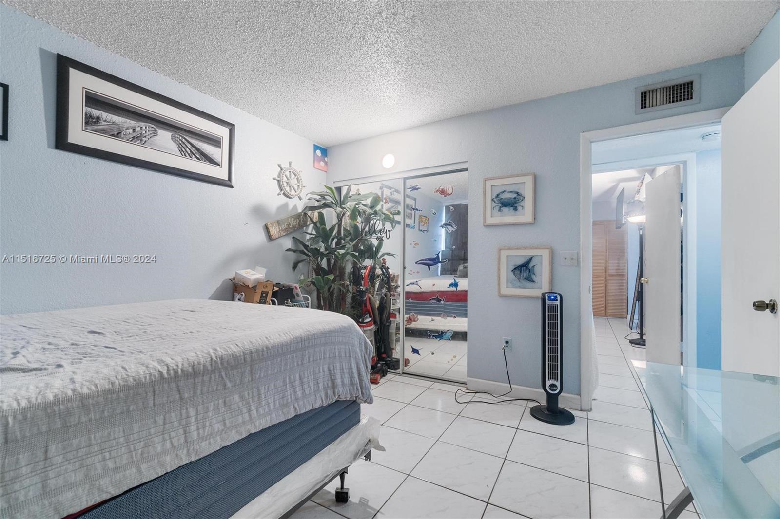 1900 West 68th Street, Unit E104 Hialeah, FL 33014 - Photo 22 of 31 a bedroom with a bed and a chandelier