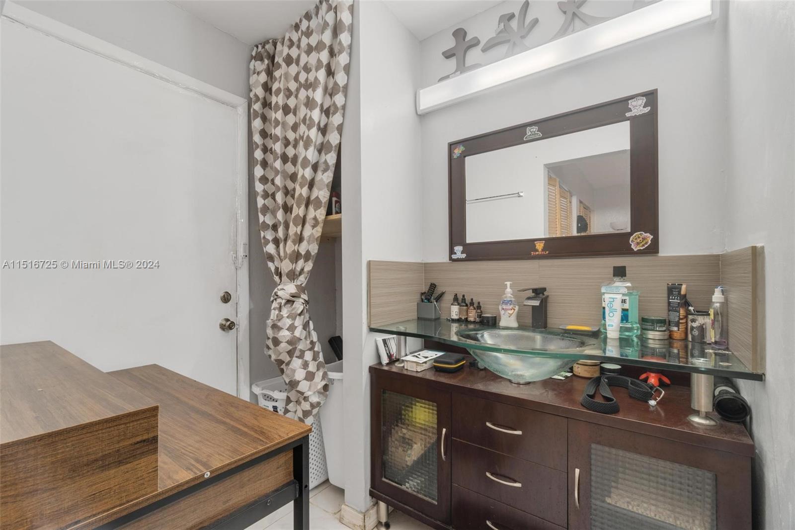 1900 West 68th Street, Unit E104 Hialeah, FL 33014 - Photo 25 of 31 a bathroom with a sink a mirror and a shower