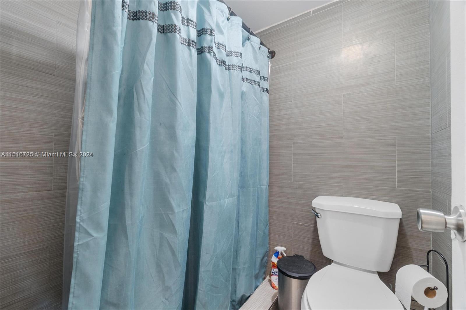 1900 West 68th Street, Unit E104 Hialeah, FL 33014 - Photo 26 of 31 a white toilet sitting next to a shower curtain