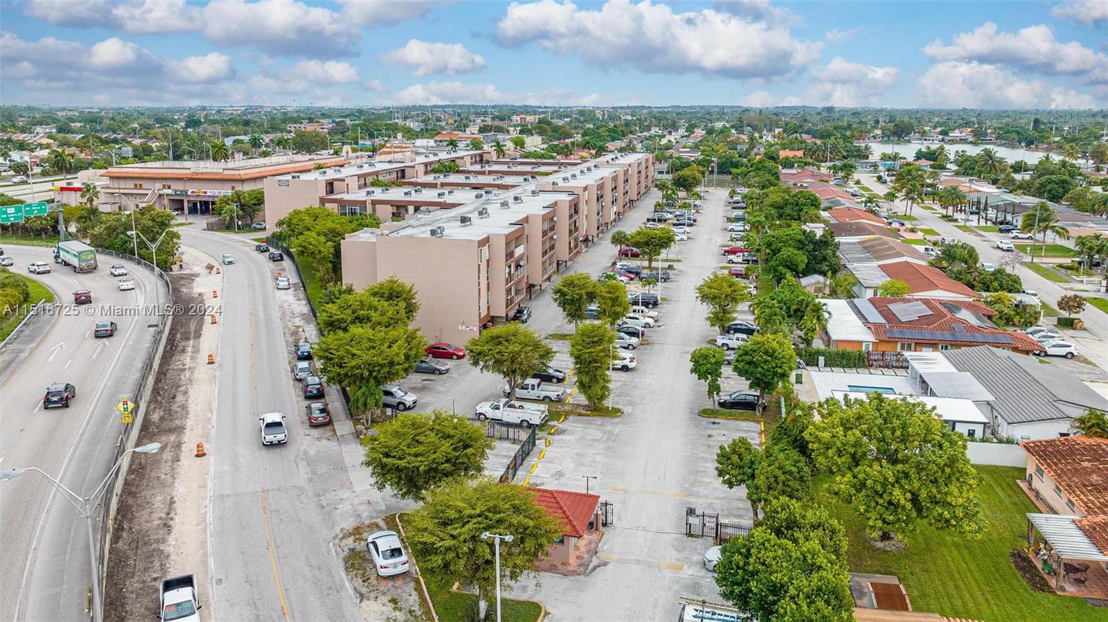 1900 West 68th Street, Unit E104 Hialeah, FL 33014 - Photo 4 of 31 an aerial view of a city with lots of residential buildings ocean and mountain view in back