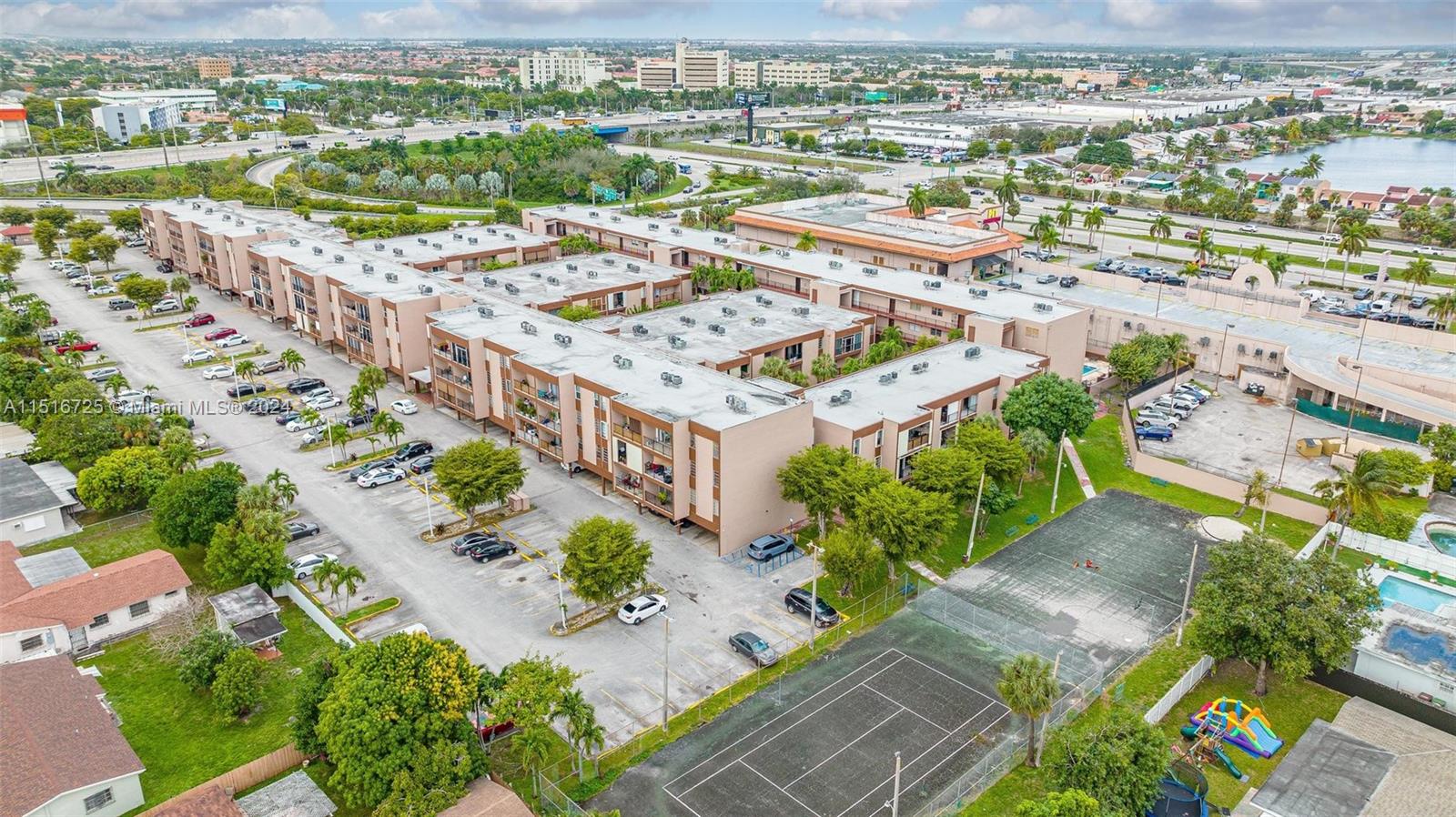 1900 West 68th Street, Unit E104 Hialeah, FL 33014 - Photo 6 of 31 an aerial view of a city with lots of residential buildings ocean and mountain view in back