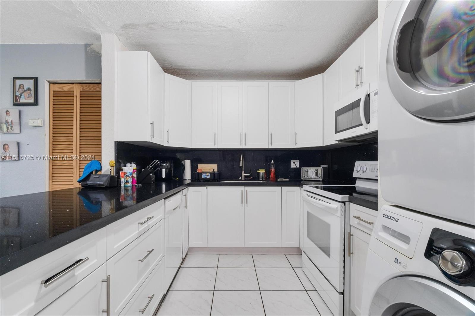 1900 West 68th Street, Unit E104 Hialeah, FL 33014 - Photo 7 of 31 a kitchen with stainless steel appliances granite countertop a sink and cabinets