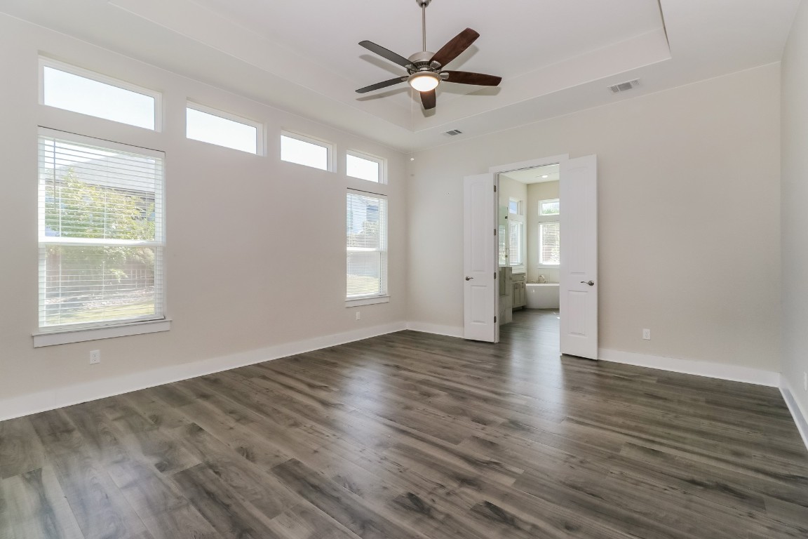 6101 Antelope Well Lane Austin, TX 78738 - Photo 14 of 36 a view of an empty room with wooden floor and a window