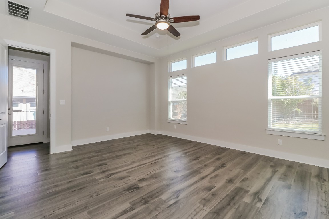 6101 Antelope Well Lane Austin, TX 78738 - Photo 15 of 36 an empty room with wooden floor chandelier fan and windows