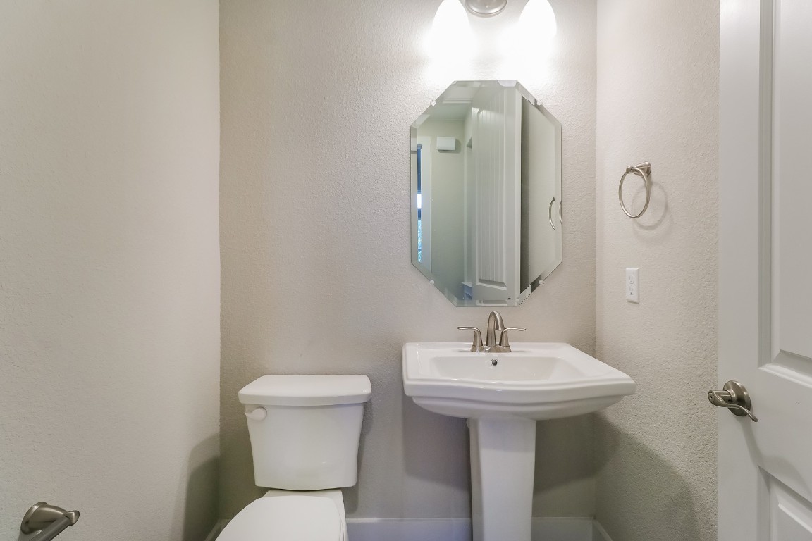 6101 Antelope Well Lane Austin, TX 78738 - Photo 28 of 36 a bathroom with a toilet sink and mirror