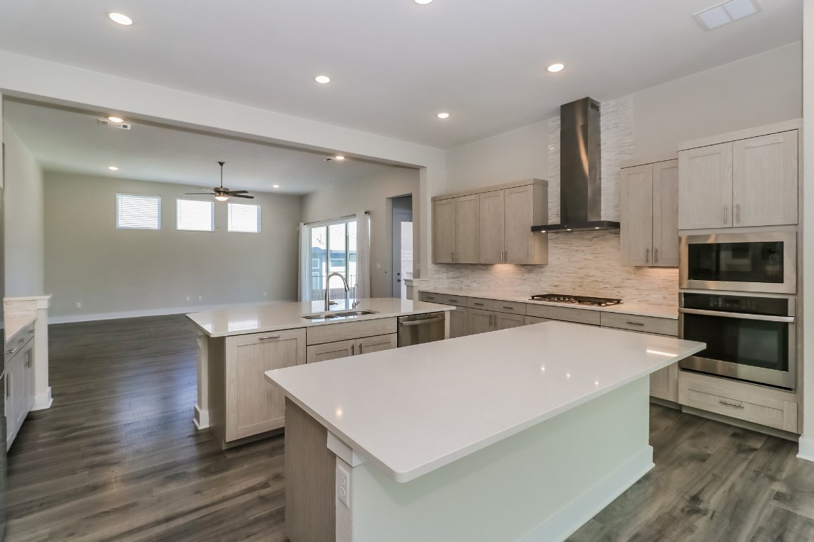 6101 Antelope Well Lane Austin, TX 78738 - Photo 9 of 36 a kitchen with stainless steel appliances a sink a stove a microwave and cabinets