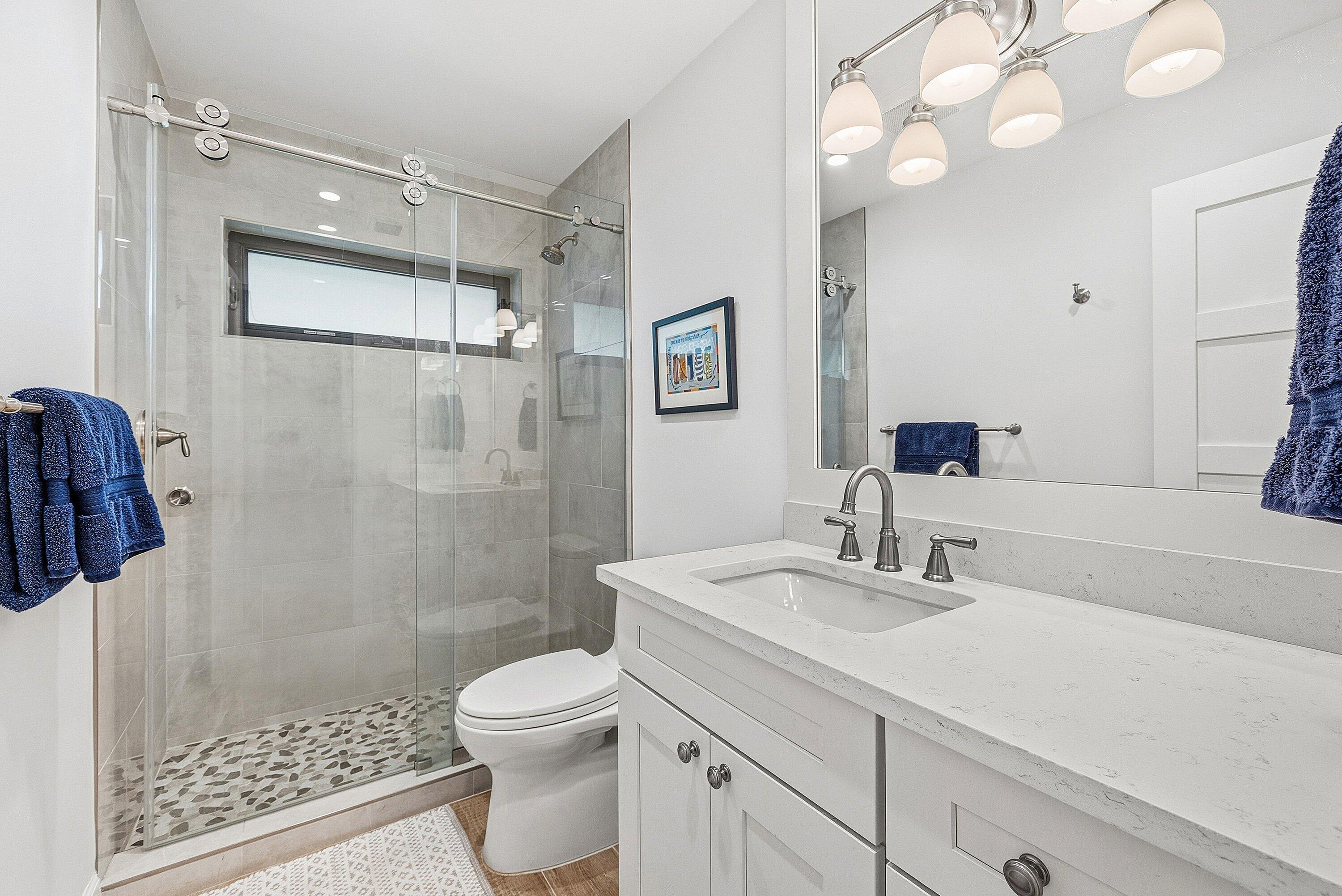 10157 Quail Covey Road, Unit HIBISCUS N Boynton Beach, FL 33436 - Photo 27 of 52 a bathroom with a sink a toilet a mirror and shower