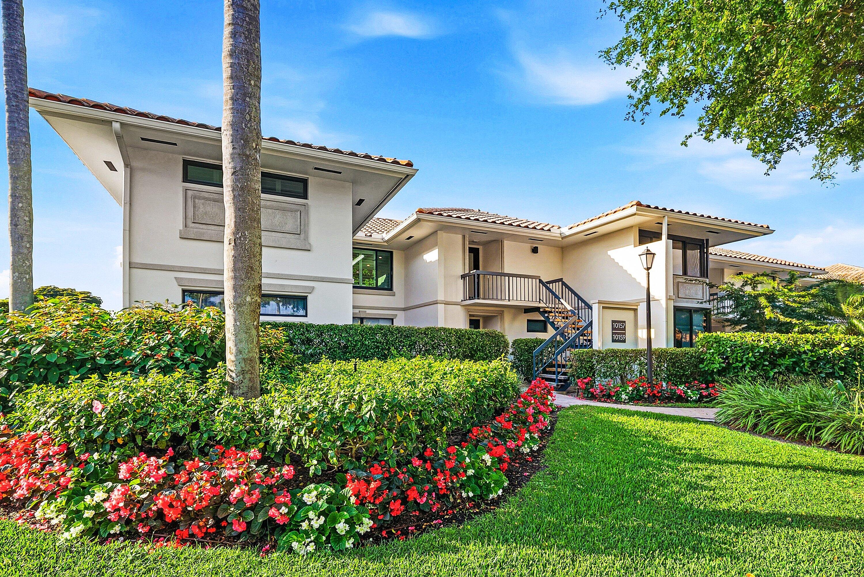 10157 Quail Covey Road, Unit HIBISCUS N Boynton Beach, FL 33436 - Photo 40 of 52 a front view of a house with a big yard and flower plants