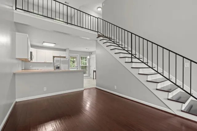 a view of staircase with wooden floor and white walls