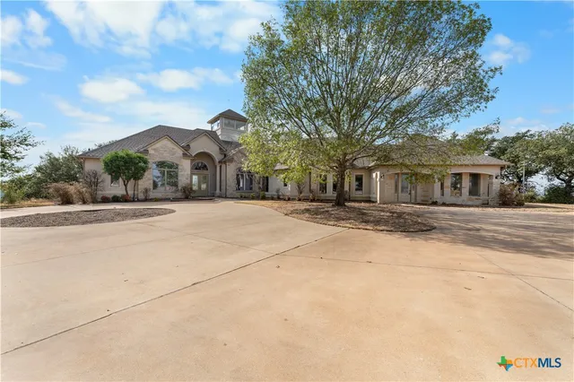 a front view of a house with a yard and trees