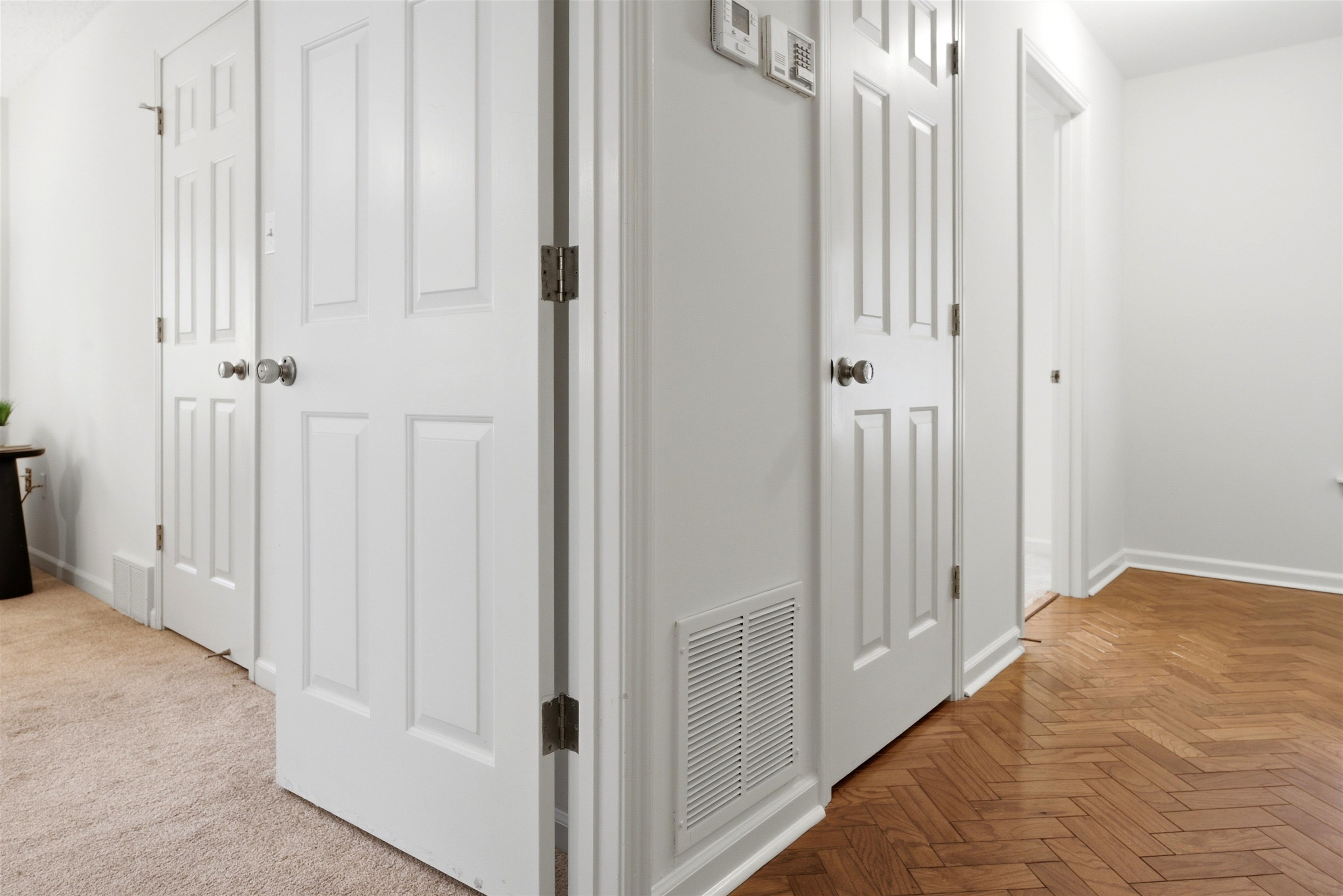 1984 Allenby Road Germantown, TN 38139 - Photo 31 of 37 Hallway featuring paneled doors, white baseboards, and wood-finish herringbone flooring