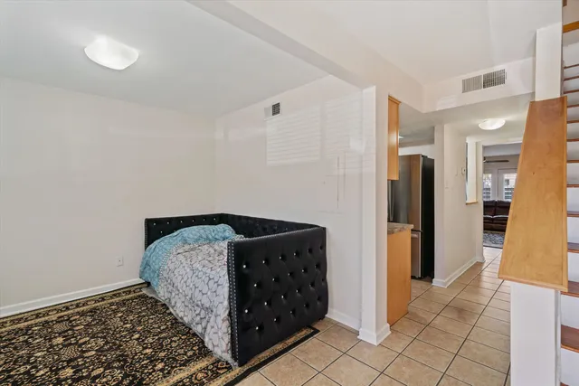 a bedroom with a bed and walk in closet with wooden floor