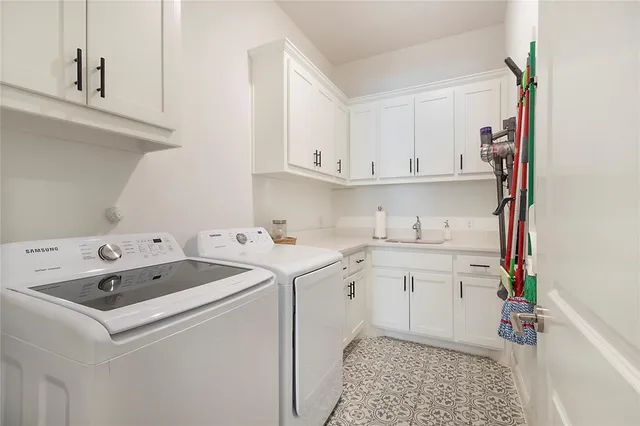 a utility room with sink dryer and washer