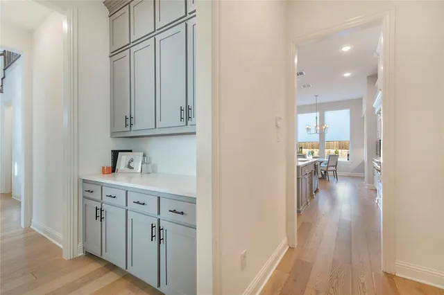 a view of a hallway with wooden floor closet and windows