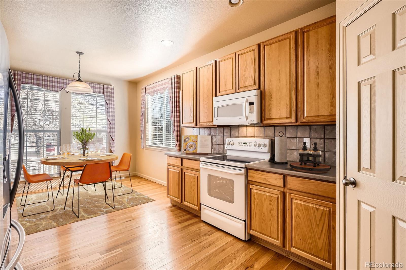 1978 Granger Circle Castle Rock, CO 80109 - Photo 9 of 31 a kitchen with stainless steel appliances granite countertop a stove top oven a sink dishwasher and white cabinets with wooden floor