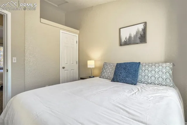 a large white bed in a bedroom next to a window