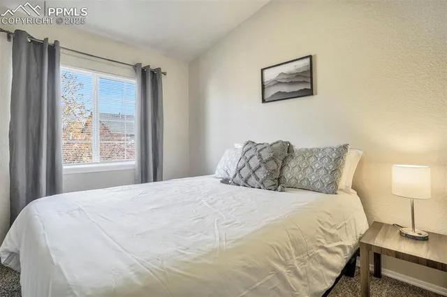 a large bed sitting in a bedroom next to a lamp