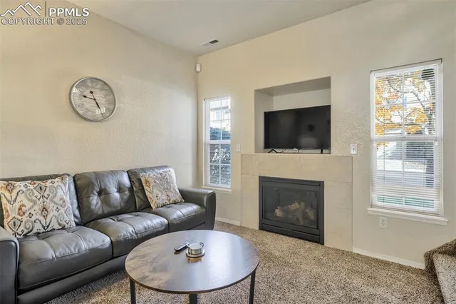 a living room with furniture a fireplace and a flat screen tv