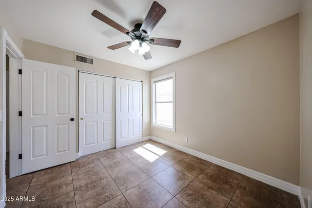 a view of a big room with closet and a chandelier fan