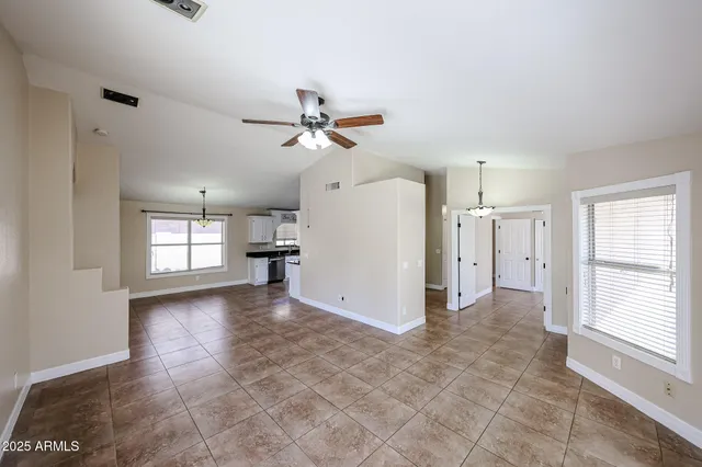 a view of a livingroom with a ceiling fan window and a kitchen view