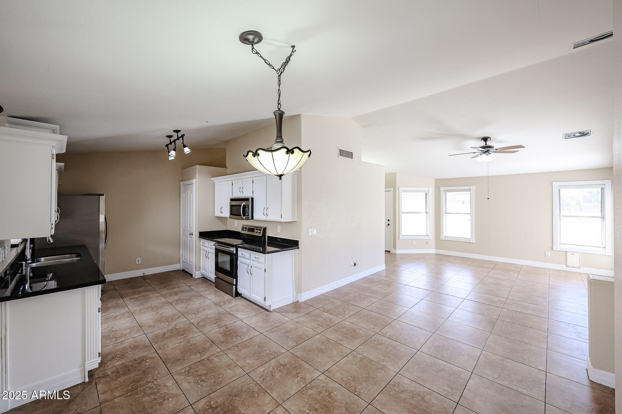 3897 East Douglas Loop Gilbert, AZ 85234 - Photo 8 of 34 a kitchen that has a sink stainless steel appliances a counter space and a window