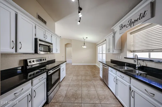 a kitchen with granite countertop a stove microwave and sink