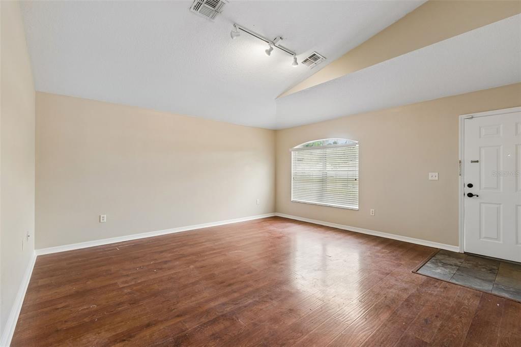 4631 Eagle Ranch Drive Zephyrhills, FL 33542 - Photo 12 of 58 a view of an empty room with wooden floor and a window