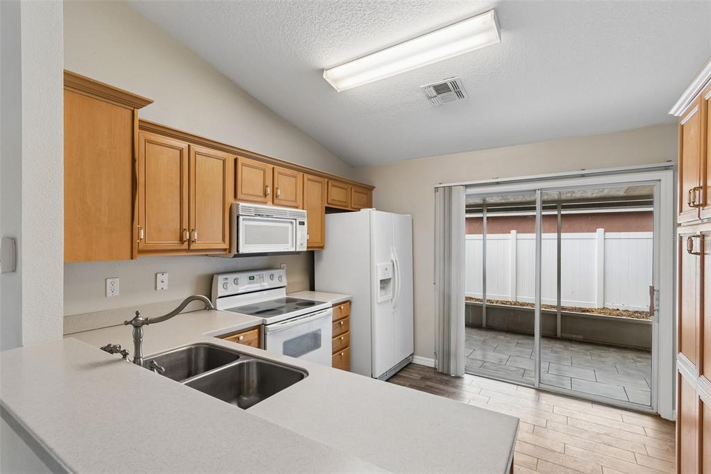 4631 Eagle Ranch Drive Zephyrhills, FL 33542 - Photo 14 of 58 a kitchen with a refrigerator sink and cabinets