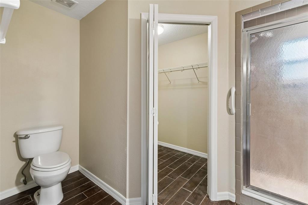 4631 Eagle Ranch Drive Zephyrhills, FL 33542 - Photo 23 of 58 a bathroom with a toilet and a glass shower door