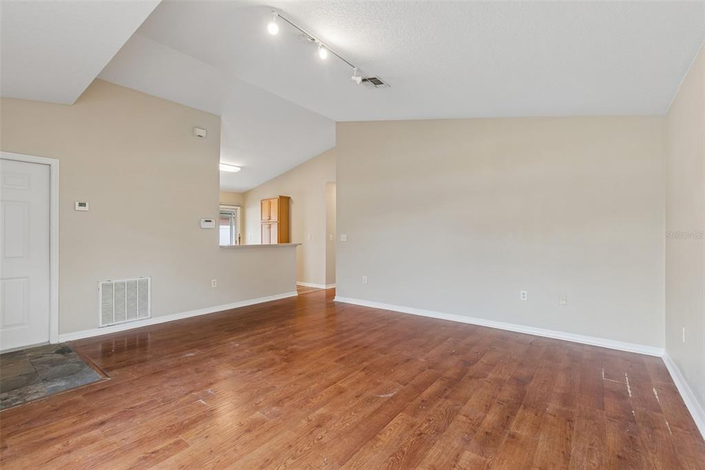 4631 Eagle Ranch Drive Zephyrhills, FL 33542 - Photo 10 of 58 a view of an empty room with wooden floor and a window