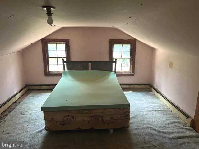 a bed sitting in a bedroom next to a window