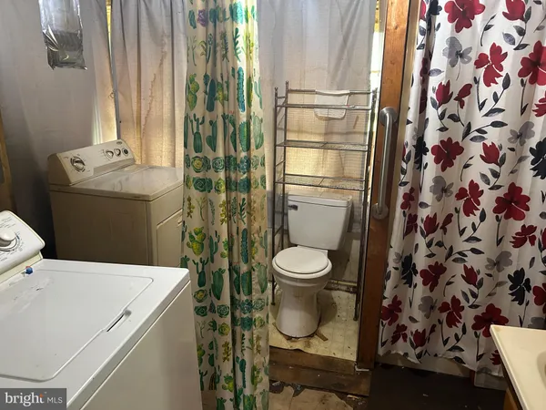 a bathroom with a toilet and a shower curtain