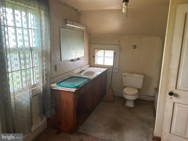 a bathroom with a granite countertop toilet sink and mirror