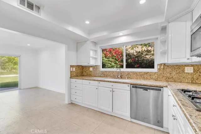 a kitchen with granite countertop a sink and a stove
