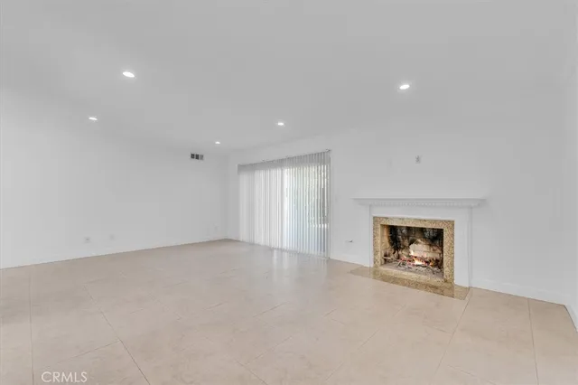an empty room with a fireplace and window