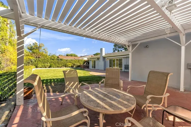 a view of a patio with table and chairs with wooden floor and fence