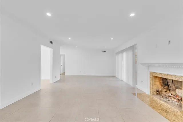 an empty room with a fireplace and mirror