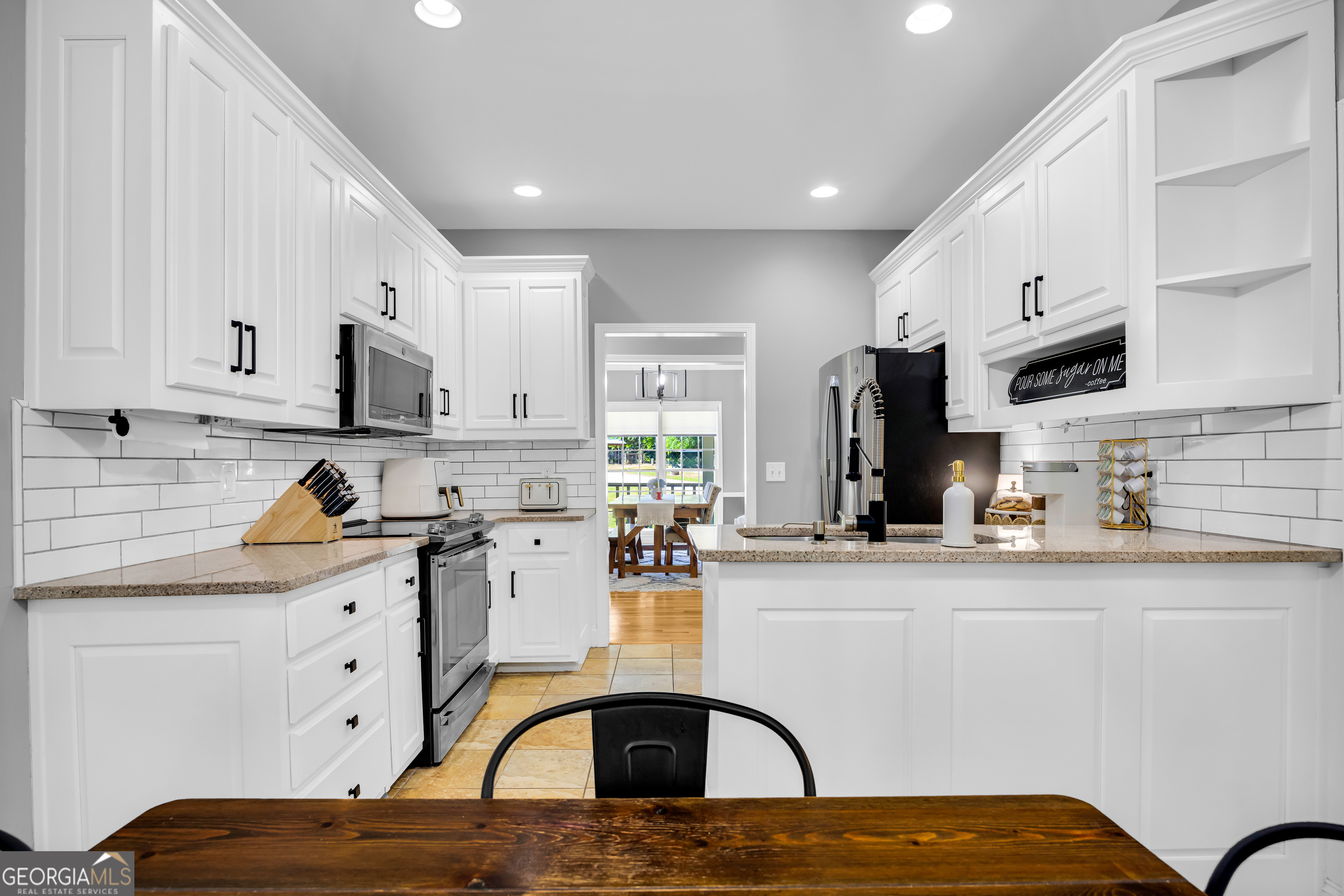 533 Emory Chambers Road Lula, GA 30554 - Photo 23 of 88 a kitchen with stainless steel appliances kitchen island granite countertop a stove a sink a refrigerator and white cabinets with wooden floor