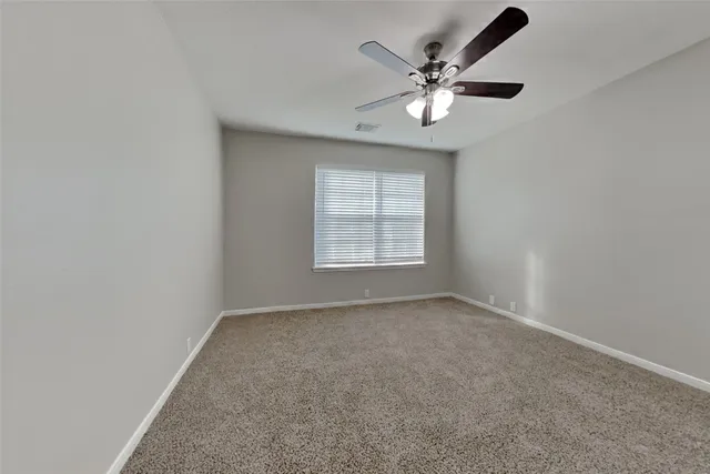 an empty room with closet and ceiling fan