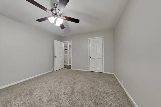 an empty room with chandelier fan