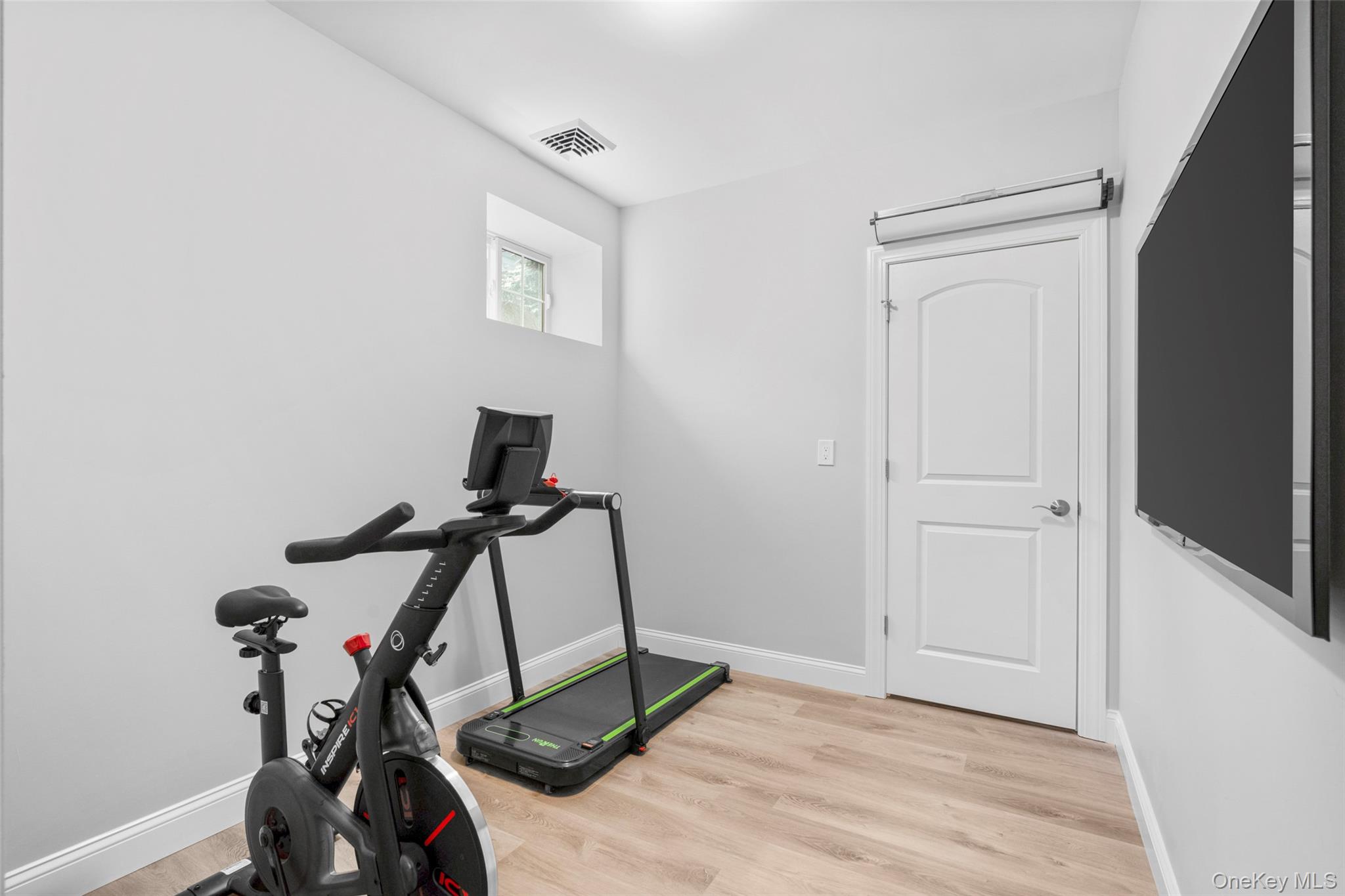 3 Robin Hill Road Scarsdale, NY 10583 - Photo 24 of 32 a room with gym equipment and windows