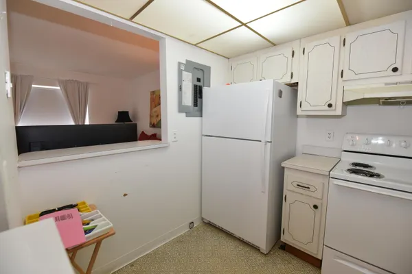 a white refrigerator freezer and a stove sitting inside of a kitchen